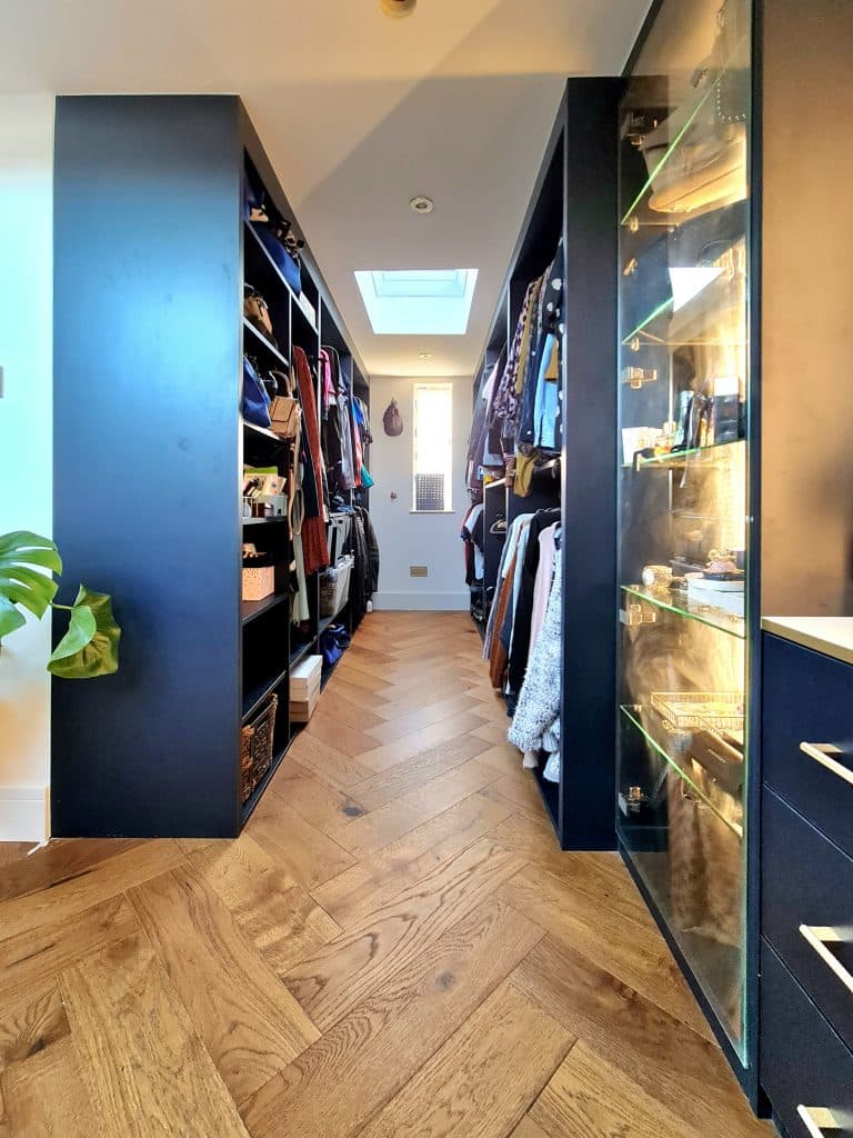 Mr Wardrobe's bespoke walk-in closet in London showcases elegant wooden floors and stylish blue walls.